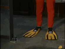 a man in a red and yellow superhero costume is standing in front of a window