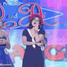 a woman in a black dress is standing in front of a miss and a sign .