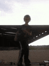 a boy in a black shirt and black pants is standing on a skateboard in front of a building