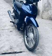 a blue motorcycle is parked on a concrete sidewalk