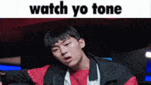 a young man in a red shirt and black jacket with the words watch yo tone on the bottom