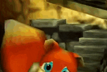 a stuffed animal with blue eyes is sitting in front of a stack of bricks .