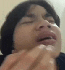 a close up of a person making a funny face with their mouth open .