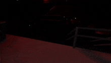 a dark room with a railing and a few lights on