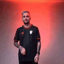 a man wearing a black adidas shirt is dancing