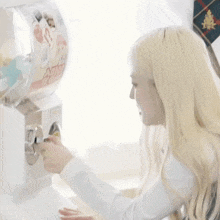 a blonde woman is playing with a candy machine that says apollo
