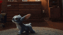 a stuffed animal is standing in front of a dresser with a sticker on it that says " stitch "