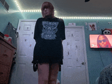 a woman wearing a black shirt that says ' justice ' on it stands in front of a tv