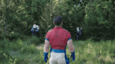 a man in a superhero costume stands in a field