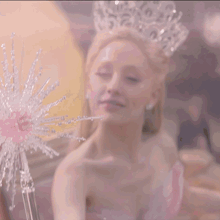 a woman in a pink dress and tiara smiles