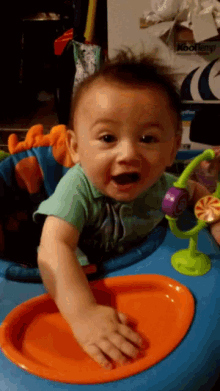 a baby is sitting in a blue walker with toys on it