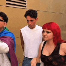 a woman with red hair is standing next to a man in a white shirt