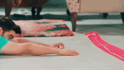 a man is laying on the floor with his arms outstretched and his legs crossed .