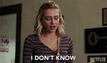 a woman says i don 't know in front of a sign for netflix