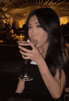 a woman is holding a martini in her hand