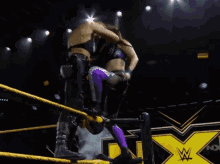 two women are wrestling in a ring with a sign that says nxt in the background