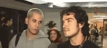 two men are looking at each other in a room .