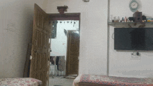 a bedroom with a clock on the wall and a flat screen tv