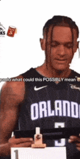 a man in a black orlando jersey is holding a piece of paper