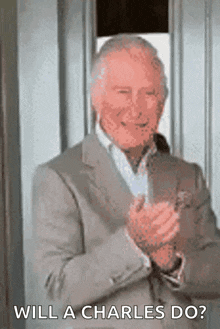 a man in a suit is clapping his hands and says " will a charles do "