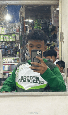 a man taking a picture of himself in a mirror wearing a green shirt that says ' i love you ' on it