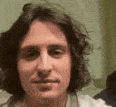 a close up of a man 's face with curly hair .