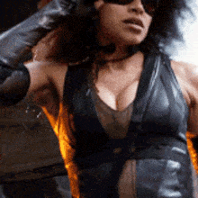 a woman is wearing sunglasses and a black leather dress