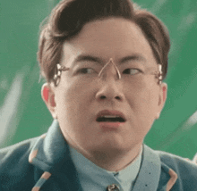 a man wearing glasses is making a funny face .