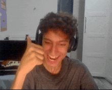 a young man wearing headphones is giving a thumbs up sign