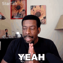 a man in a black shirt is saying yeah