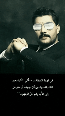 a man in a suit and tie wearing sunglasses with arabic writing on the bottom