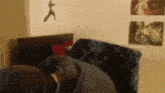 a person is laying on a couch in a bedroom with a picture of a man on the wall .
