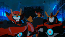 two transformers are standing next to each other and one has the word transformers on his chest