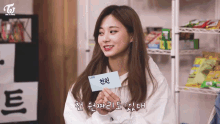 a woman holding a card with the word twice written on it
