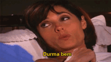a woman is laying in bed with the word durma bem written in yellow