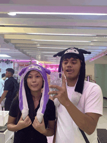 a man and a woman are posing for a picture in front of a sign that says ' candy ' on it