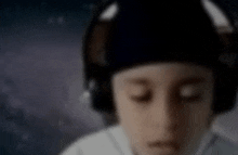 a blurry picture of a child wearing headphones with his eyes closed .