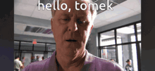 a man in a purple shirt says hello tomek on the screen
