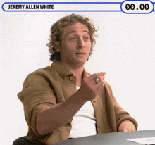 jeremy allen white is sitting at a table talking