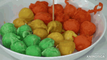 a white bowl filled with different colored balls with the words made in animatica on the bottom