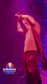 a man singing into a microphone on a stage with the words indochine fans peru below him