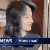 a woman is standing in front of a news banner that says hoes mad .