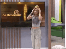 a woman is wearing a crown and standing in front of a television .