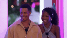 a man and a woman are standing next to each other smiling .