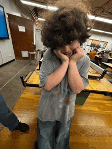 a boy with curly hair is making a funny face