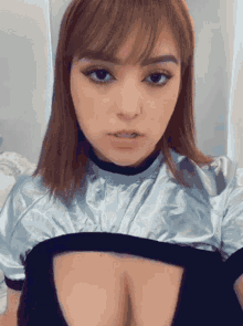a woman with braces on her teeth is taking a selfie with her breast exposed