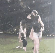 a group of people are standing in a field with a baby .