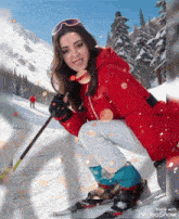 a woman in a red jacket is skiing down a snowy slope