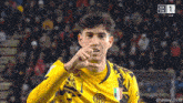 a soccer player wearing a yellow jersey with the number 1 on the back