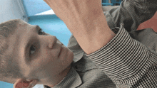 a young man wearing a plaid shirt is looking up